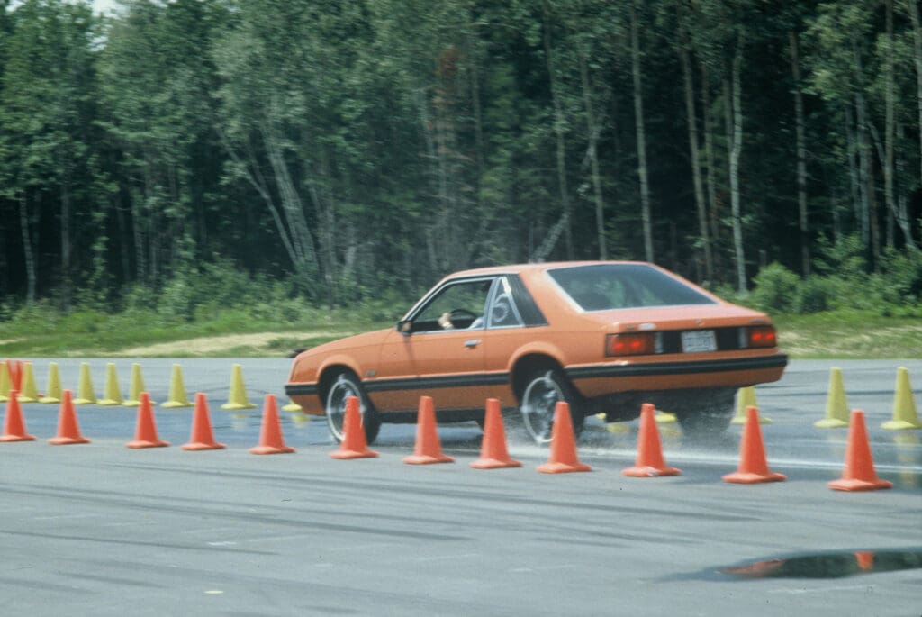 Vieille voiture effectuant des manœuvres autour de cônes